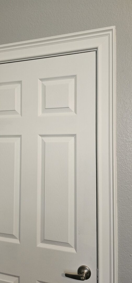 A white door with six panels and a black frame.