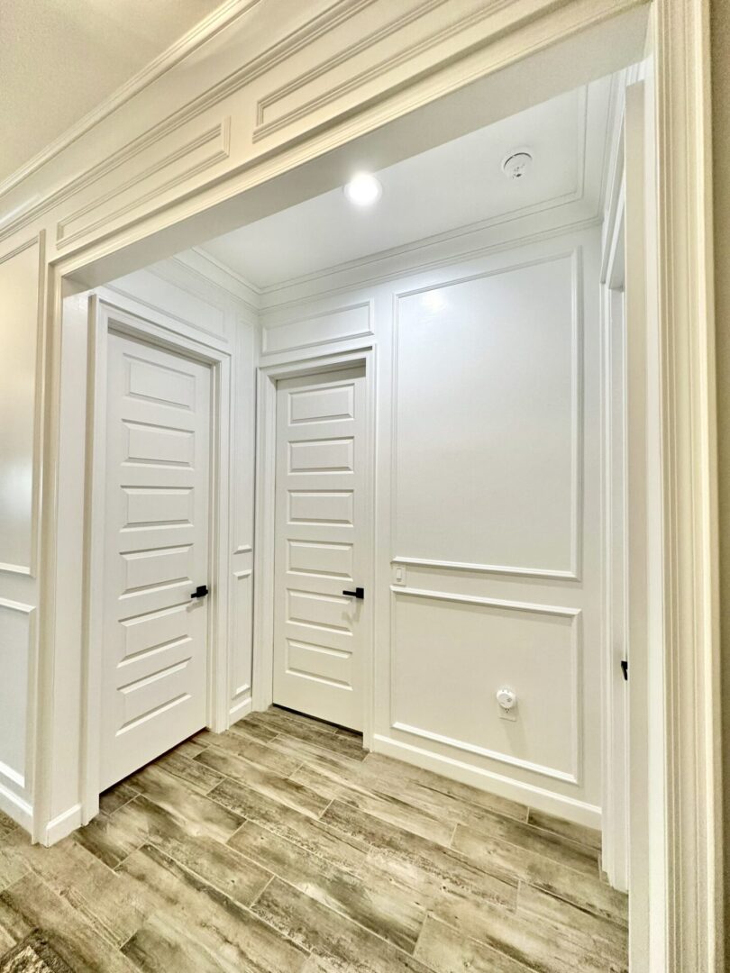 A room with two doors and white walls.