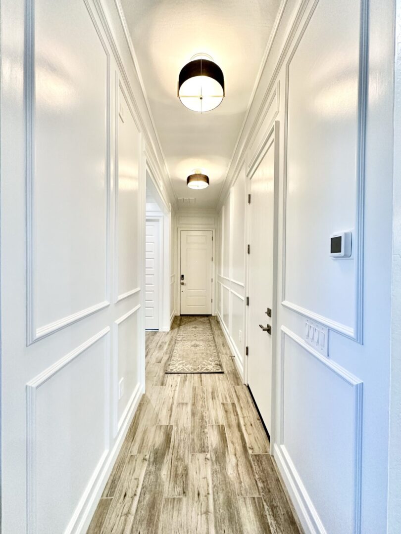 A hallway with two doors and white walls.