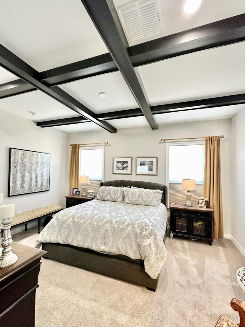 A bedroom with white walls and black furniture.