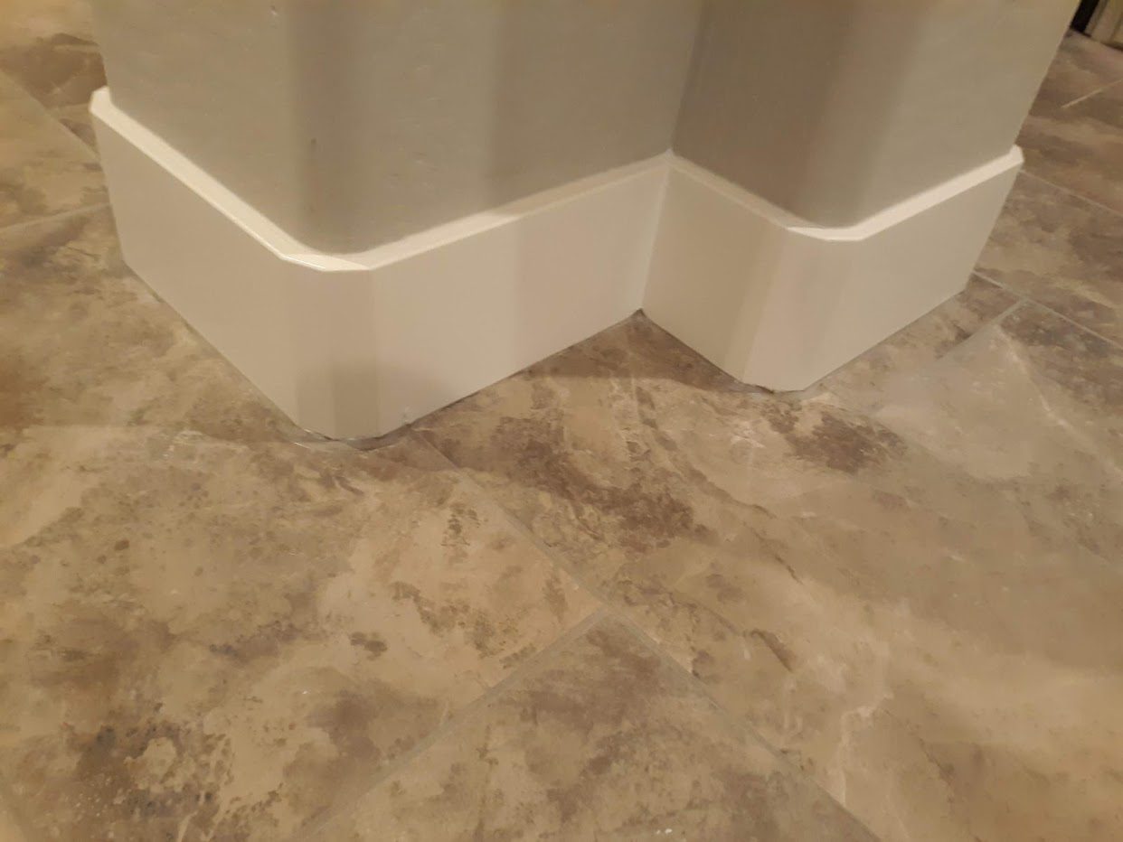 A bathroom floor with a white shower curtain.