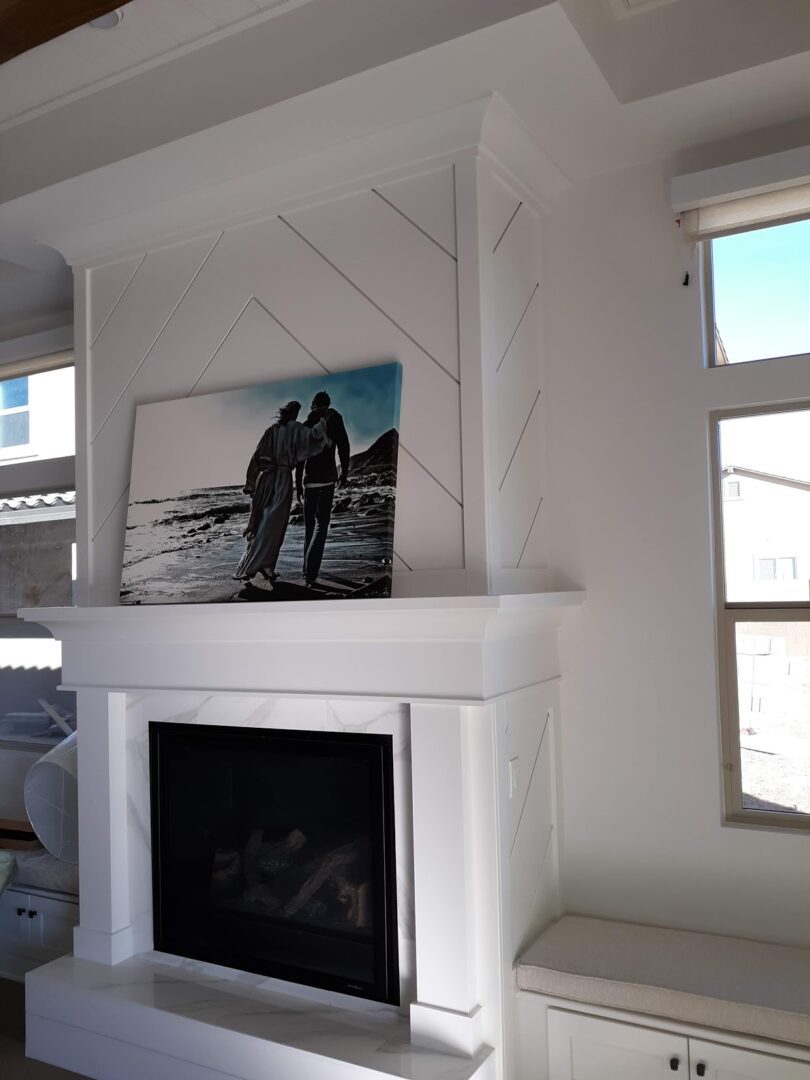 A fireplace with a picture hanging above it.