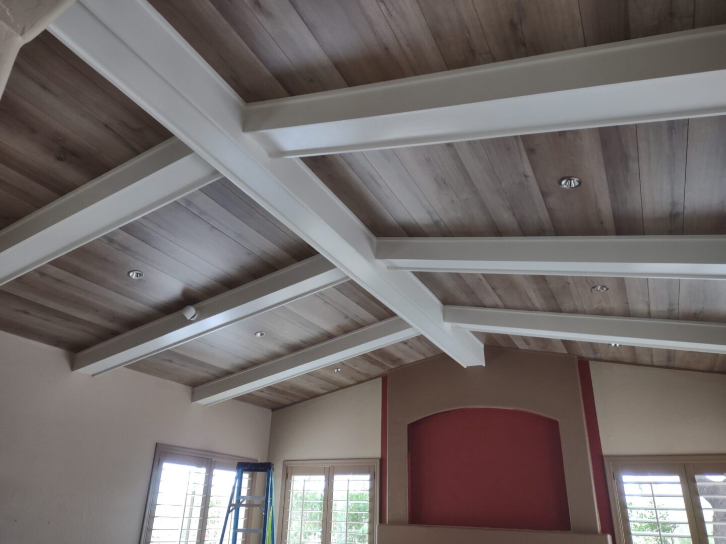 A room with wooden ceiling beams and red wall.