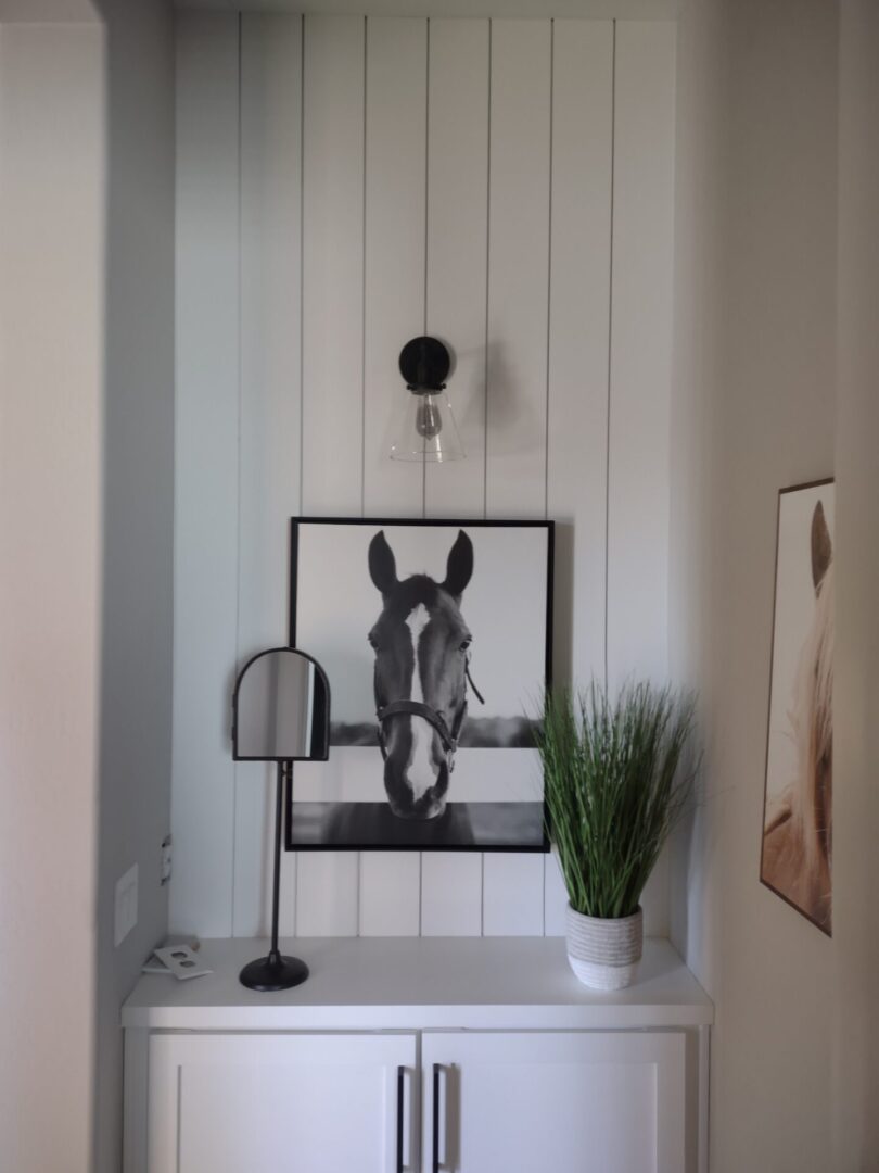 A horse picture is hanging on the wall.