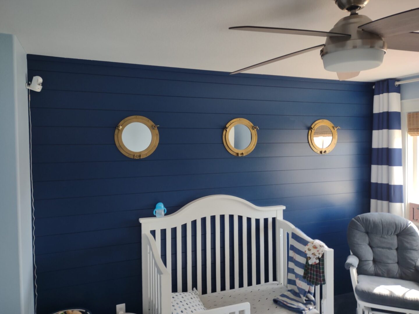 A baby 's room with blue walls and white furniture.