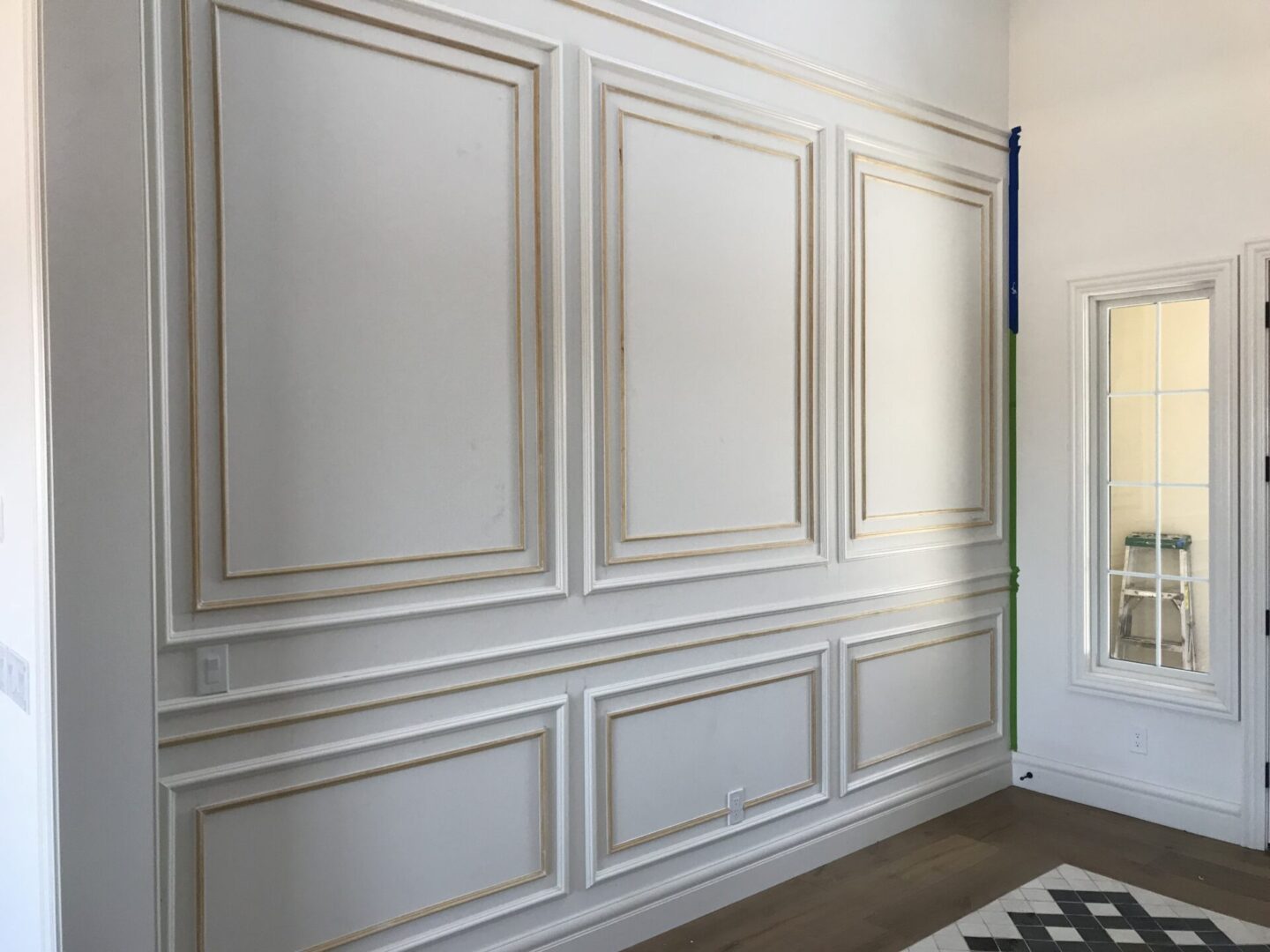 A white wall with some wood trim on it