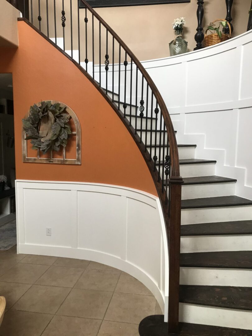 A curved staircase with wood steps and black metal railing.