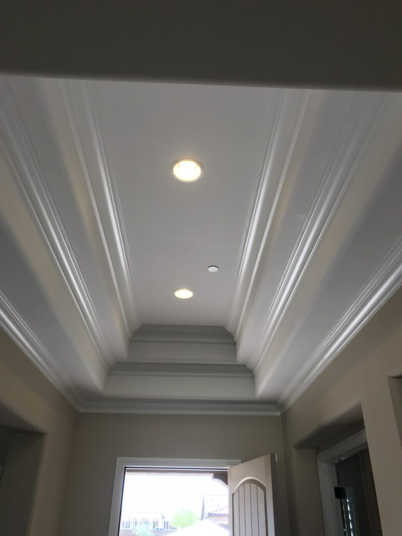 A hallway with two lights and a ceiling.