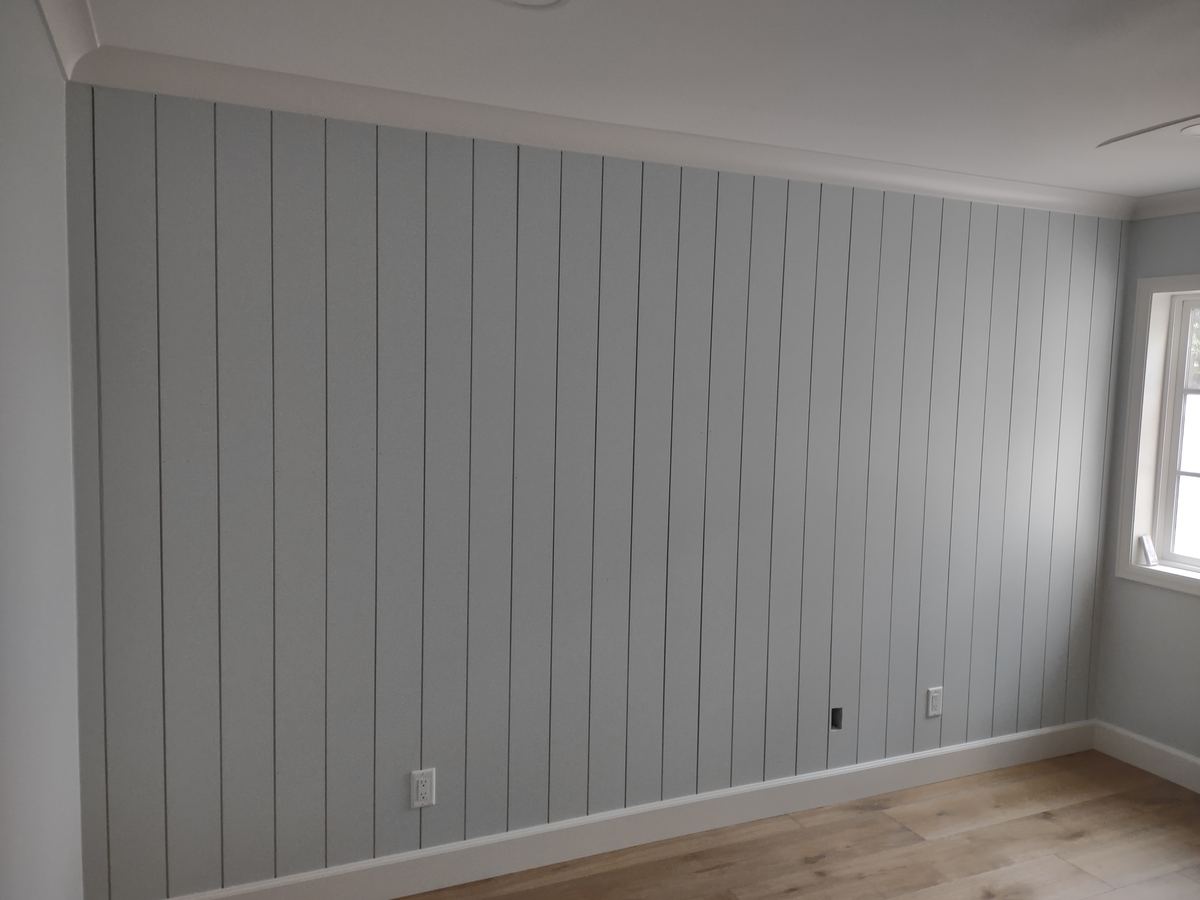 Custom vertical shiplap feature wall with floor-to-ceiling paneling